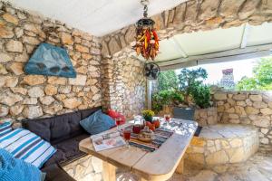 a living room with a table and a stone wall at Libera Apartments in Stara Baška