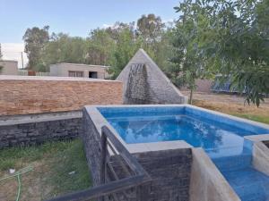 a swimming pool in a yard next to a brick wall at Oasis Pueyrredón in Rodeo del Medio