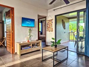 a living room with a table and a couch at Teahupo'o Lodge Tahiti - Maison familiale au cœur du village - Canoës inclus in Teahupoo