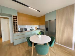 a kitchen with a white table and green chairs at Ins apartment - 2 bedrooms - metro parking prive in Bagnolet