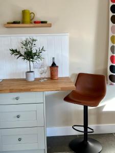 a desk with a chair and a bottle and glasses at Chiltern Studio in Wendover