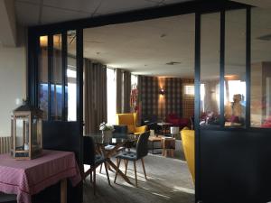 a living room with a table and yellow chairs at Hôtel Panorama in Munster