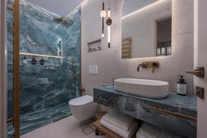 a bathroom with a sink and a toilet and a shower at Mountain Pine Luxury Suites in Florina
