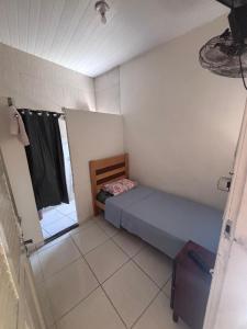 a small bedroom with a bed and a window at Pousada Mara Mar Niterói in Niterói