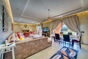 a living room with a couch and a dining room at Villa Maloulou in Marrakesh