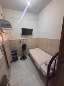 a small room with a bed and a television at Pousada Mara Mar Niterói in Niterói