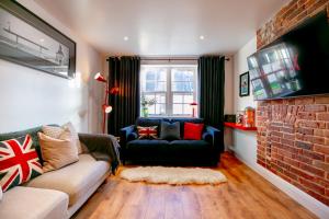 a living room with a couch and a brick wall at The Simms Suite in Worthing