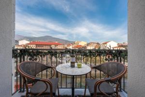 a table with two chairs and a bottle of wine on a balcony at Mountain Pine Luxury Suites in Florina +49 photos