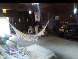 a hanging hammock in a room with a couch at Casa Da MAELA in Corumbau