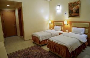 a hotel room with two beds and a rug at Jawaher hotel in Karbala