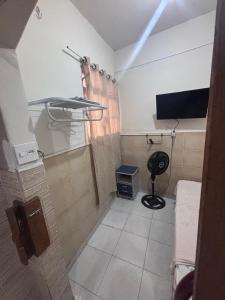 a room with a tv and a chair in it at Pousada Mara Mar Niterói in Niterói