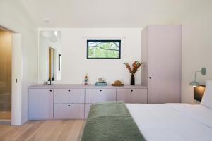 a white bedroom with a bed and a window at Three Ducks in Westhampton