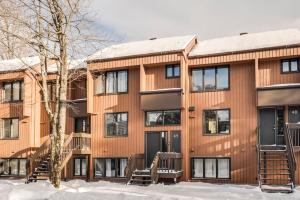 an apartment building in the snow with a tree at La Bergerie 49 - Ski-in Ski-out in Beaupré