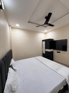 a bedroom with a bed and a ceiling fan at Hotel Shivlok Inn in Ujjain +20 photos