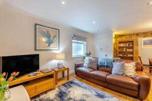 a living room with a leather couch and a flat screen tv at 2 Bed in Bamburgh oc-gd1273 in Bamburgh