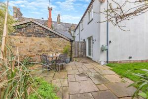 an exterior view of a cottage with a table and chairs at 2 Bed in Bamburgh oc-gd1273 in Bamburgh