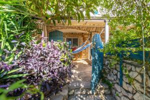 a garden entrance to a house with purple flowers at Libera Apartments in Stara Baška +55 photos
