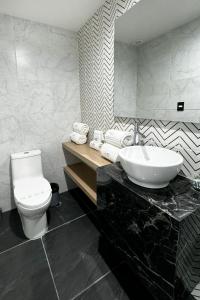 a bathroom with a white toilet and a sink at Rest Inn Baja in Ensenada