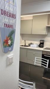a kitchen with a sign that says dreams travel at Apartamento Caminho da Praia in Pedro Miguel