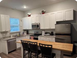 a kitchen with a wooden table and white cabinets at Beautiful modern 3 bed 2 bath in Fort Worth