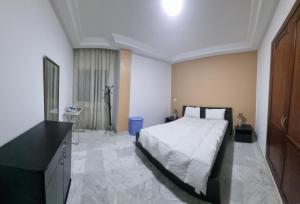 a bedroom with a large white bed and a television at Luxe studio tunisia mall lac 2 in Tunis