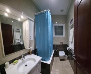 a bathroom with a sink and a blue shower curtain at Luxe studio tunisia mall lac 2 in Tunis