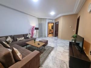 a living room with a couch and a table at Luxe studio tunisia mall lac 2 in Tunis