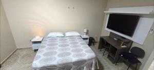 a bedroom with a bed and a flat screen tv at Base Luz na Floresta in Manaus
