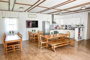 a kitchen and dining room with wooden tables and chairs at Valle vandrarhem och camping in Axvall