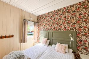 a bedroom with a bed and a floral wall at Valle vandrarhem och camping in Axvall