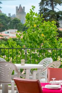 a white table and chairs on a patio with a view at Cerise Carcassonne Sud in Carcassonne