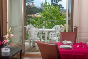 a dining room with a table and chairs on a balcony at Cerise Carcassonne Sud in Carcassonne