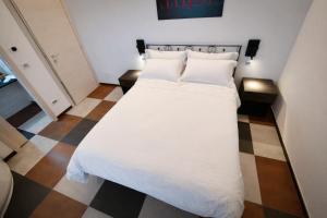 a bed with white sheets and pillows in a room at IL CAMBUSIERE nature relais in Ortona