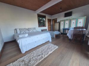 a bedroom with a bed and a table and chairs at Pedra Azul Chalé Clássico in Domingos Martins
