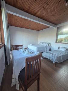 a room with two beds and a table and chairs at Pedra Azul Chalé Clássico in Domingos Martins +6 photos