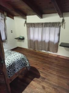a bedroom with a bed and a window with curtains at Cabaña lagunita in Sabinas