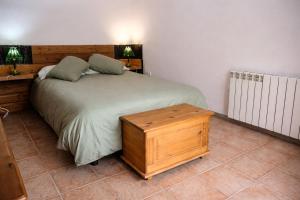a bedroom with a large bed with a wooden headboard at Casa La Farrapona Torrestío Babia in Torrestío
