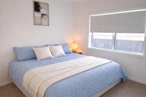 a bedroom with a blue bed with a window at Spring Haven in Wagga Wagga