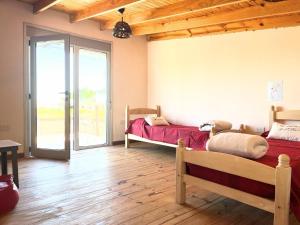 two beds in a room with wooden floors and a window at Village Pehuen in Balneario Pehuén-Có