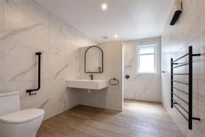 a white bathroom with a sink and a toilet at Havelock North Holiday Park in Havelock North +60 photos