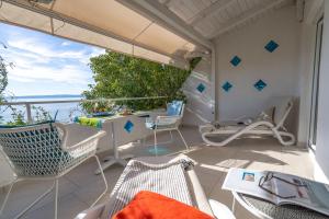a balcony with chairs and a table and an umbrella at Libera1 in Stara Baška