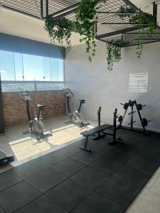 a gym with treadmills and exercise bikes in a room at Apartamento Studio in Barbacena
