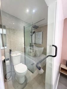 a bathroom with a toilet and a glass shower stall at MAISON 9 Apartments Surulere in Lagos +54 photos