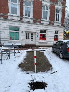 a car parked in front of a building in the snow at Gemütliche 3-Zimmer-Wohnung mit Parkplatz in Itzehoe