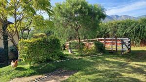 a yard with a fence and chickens in the grass at Rancho Ca Fé - Casa Rural in Brazópolis