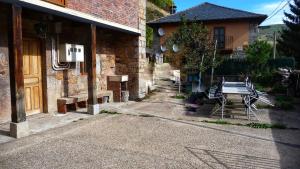a building with a bench sitting outside of it at Casa La Farrapona Torrestío Babia in Torrestío