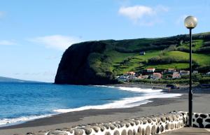 a view of a beach with houses and the ocean at Apartamento Caminho da Praia in Pedro Miguel