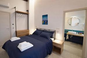 a bedroom with a blue bed and a sink at IL CAMBUSIERE nature relais in Ortona +16 photos