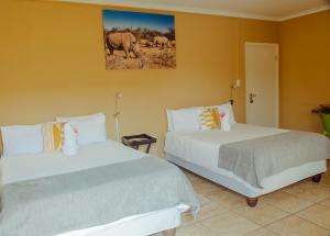 a bedroom with two beds and a picture of elephants at Josef Self Catering in Swakopmund