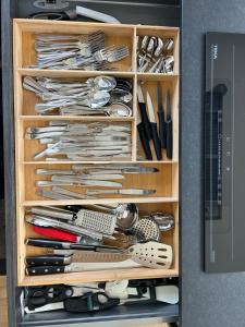 a wooden drawer filled with lots of utensils at Villa los corzos in Oviedo +40 photos